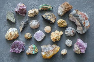 Mineral taşlar koleksiyonu: turkuaz, morion, dumanlı kuvars, rhinestone, chalcedony, akik, ametist, oniks, gri beton arka plan üzerinde chalcedony. Üstte görüntü.