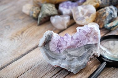 Mineral taşlar koleksiyonu. Ön planda akik ve büyüteç ile Ametist.