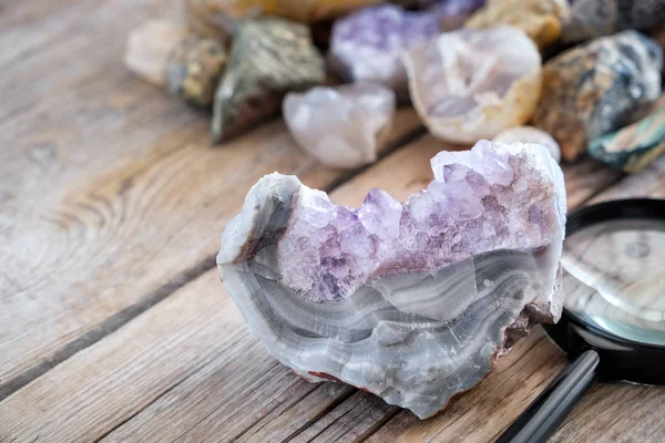 Mineral stones collection. Amethyst with agate and magnifying glass in the foreground. — Stock Photo, Image