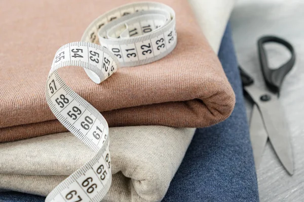 Stapel von Strickwaren, Scheren und Maßband. — Stockfoto