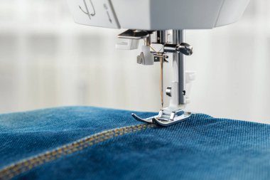 Dikiş makinesi ile denim kot dikiş. Denim kumaş dikiş dikiş makinesi nin iğne yakın.