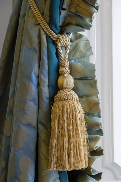 Luxury tassel in golden color close up and beautiful curtain. — Stock Photo, Image