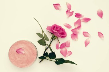 Ev yapımı nemlendirici krem ve pembe gül çiçekli kavanoz. Üst görünüm.