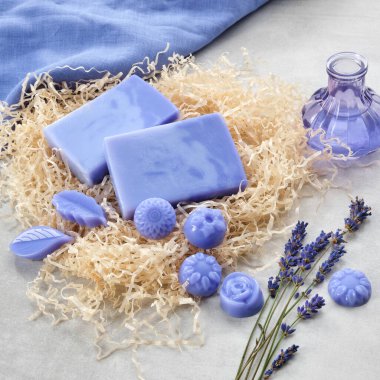 Homemade lavender soap bars and candy shaped soap, lavender extract bottle and dry lavender flowers. Top view. clipart