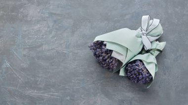 Gri arka planda iki lavanta çiçeği buketi. Düz yatıyordu. Üst Manzara. Metin için alanı kopyala.