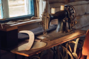 Eski antika dikiş makinesi, ahşap dikiş düzeni ve terzi atölyesinde yalancı kumaşlar..
