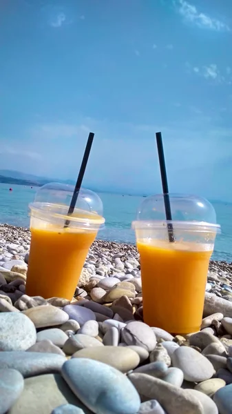 Due Bicchieri Succo Arancia Fresco Sulla Spiaggia Ghiaia Giorno — Foto Stock