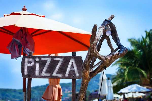 Un panneau publicitaire Pizza sur la plage — Photo