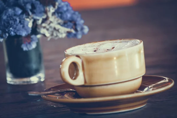 Eine Tasse Kaffee und ein Strauß auf Holztebel — Stockfoto