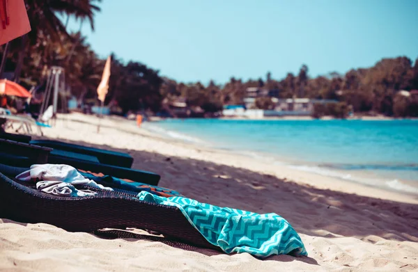 Vista tonificada da praia tropical com o leito de sol e bagunça nela — Fotografia de Stock
