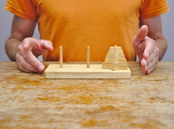 Man about to attempt Tower of Hanoi mathematical puzzle