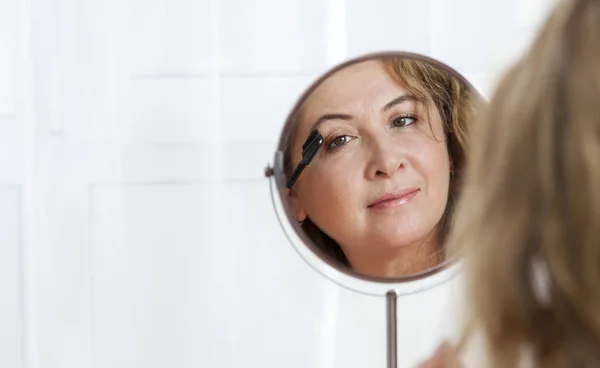 거울을 보고 있는 아름다운 건강한 성인 백인 여성 로열티 프리 스톡 이미지