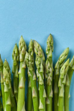 Doku üzerinde mavi arka plan, vegan gıda yeşil kuşkonmaz (kuşkonmaz officinalis)