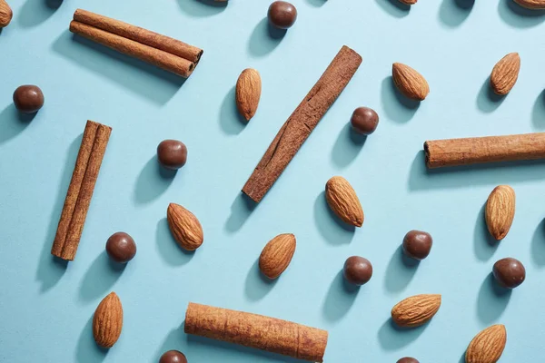 Patroon Van Amandelen Kaneelstokjes Chocolade Druppels Blauwe Achtergrond Bovenaanzicht Gezonde — Stockfoto