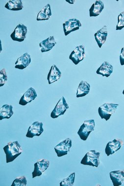 Güzel gölgeler, düz ile mavi bir arka plan üzerinde izole içecekler için buz parçaları düzgün satırı yatıyordu