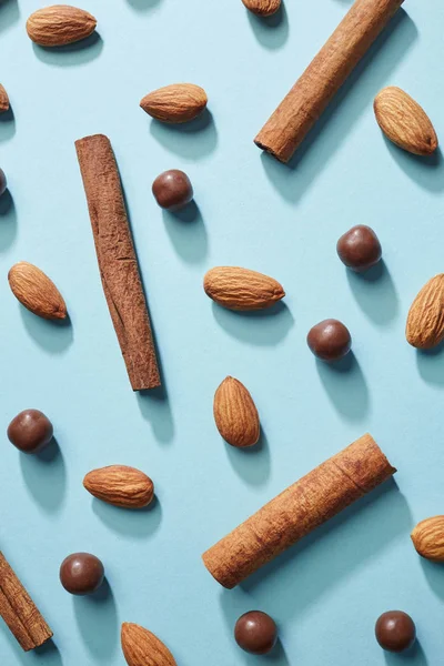 Patroon Van Amandelen Kaneelstokjes Chocolade Druppels Blauwe Achtergrond Bovenaanzicht Gezonde — Stockfoto