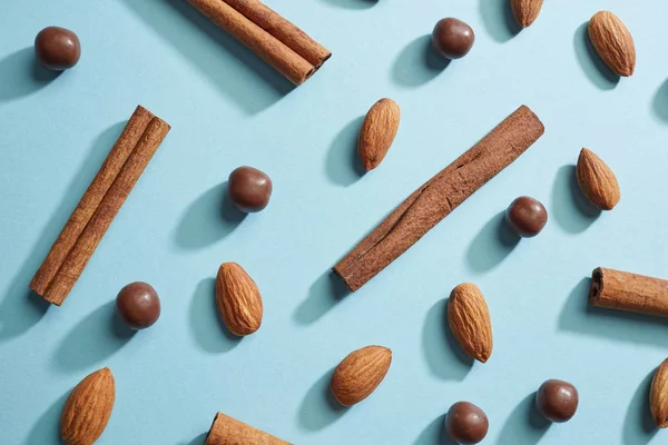 Patrón Almendras Palitos Canela Gotas Chocolate Sobre Fondo Azul Vista —  Fotos de Stock