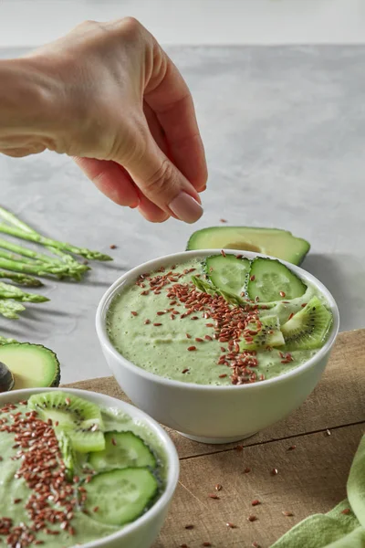 Frau Gibt Leinsamen Schalen Mit Grünem Smoothie Aus Spinat Kiwi — Stockfoto