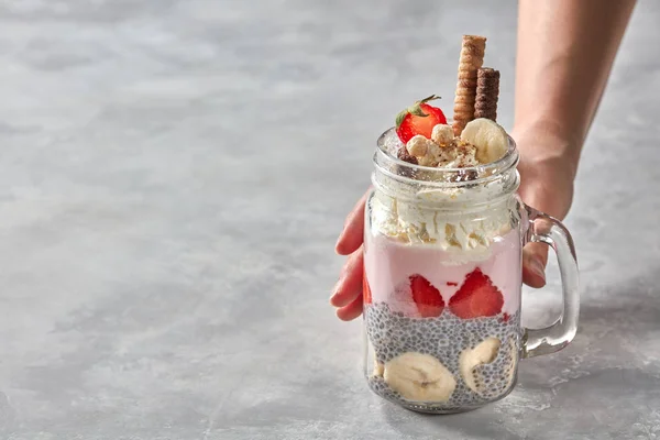 Vrouwelijke Hand Met Pot Met Gelaagde Dessert Van Yoghurt Aardbei — Stockfoto