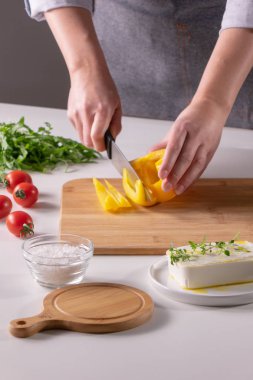 female hands cutting pepper into pieces to make a salad, step-by-step recipe clipart