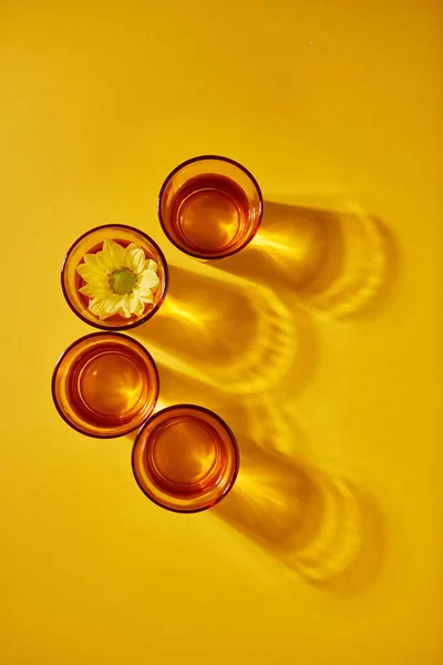 Cuatro Vasos Transparentes Amarillos Con Agua Flor Amarilla Sobre Fondo — Foto de Stock