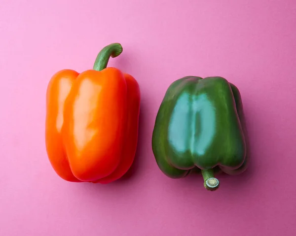 Two Whole Orange Green Paprika Peppers Pink Background Flat Lay — Stock Photo, Image