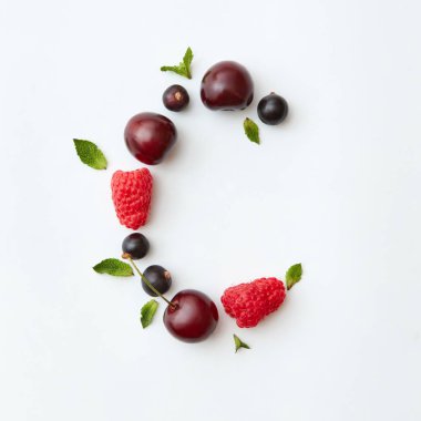 Mektup C alfabe yapılan doğal organik çilek, Olgun taze ahududu, siyah frenk üzümü, kiraz İngilizce, beyaz zemin üzerine yeşil nane yaprakları