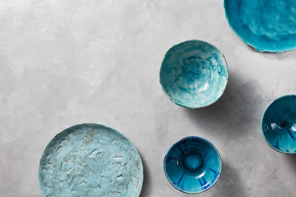 colorful porcelain handmade pottery bowls on stone gray background 