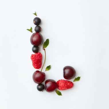 Mektup L alfabe yapılan doğal organik çilek, Olgun taze ahududu, siyah frenk üzümü, kiraz İngilizce, beyaz zemin üzerine yeşil nane yaprakları