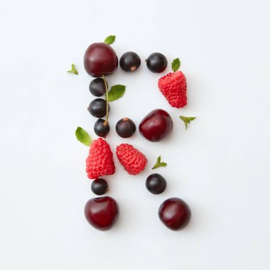 Mektup R alfabe yapılan doğal organik çilek, Olgun taze ahududu, siyah frenk üzümü, kiraz İngilizce, beyaz zemin üzerine yeşil nane yaprakları