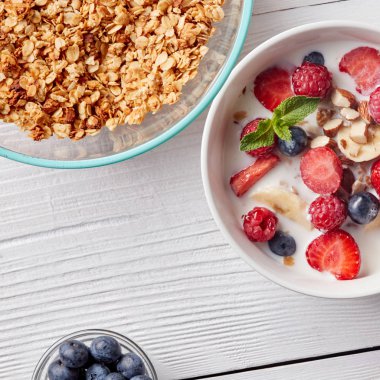 Seramik beyaz kase doğal gıda kopya alanı ile beyaz bir tablo. Lezzetli sağlıklı organik kahvaltı hazırlarken. Doğal organik detoks diyet kavramı.