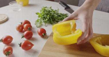 domates, yarım ahşap tahta, peynir ve taze otlar taze malzemelerle salata, yemek kadın için beyaz mutfak masasında, sarı biber