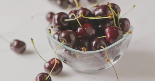 一堆新鲜的湿熟樱桃在小玻璃碗在白色桌 — 图库视频影像