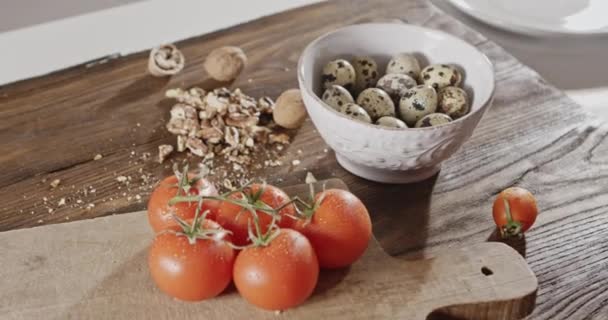 frische reife Tomaten auf Holzbrett, Wachteleier in Schüssel, Zutaten zum Salatkochen 