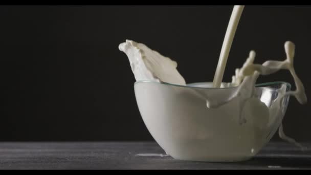 Milk Being Poured Glass Bowl Dark Background Slow Motion — Stock Video