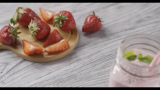 新鲜成熟的草莓和在木桌上的酸奶罐 — 图库视频影像
