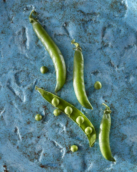 Κάτοψη Του Ένα Μπλε Κεραμικό Πιάτο Φυσικό Μικρά Πράσινα Μπιζέλια — Φωτογραφία Αρχείου