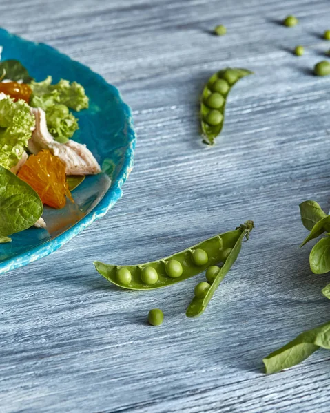 新鮮な緑のきれいな野菜 柑橘系の果物の天然の成分から自家製サラダ青セラミック プレートの半分の灰色 Woodan テーブルにエンドウ豆のさや — ストック写真