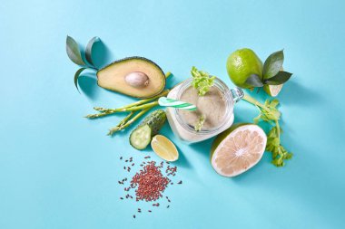 yeşil sebze ve meyve, kireç, avokado, salatalık, kuşkonmaz ve keten tohumu mavi zemin üzerine yeşil yüzlü ile jar 