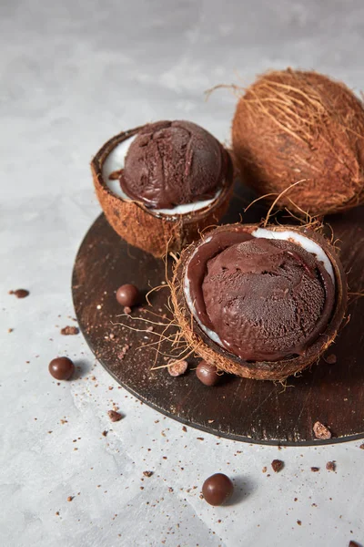 美味的巧克力冰淇淋在一个木板上的椰子壳在灰色的具体背景与地方的文本 素食饮食观 — 图库照片