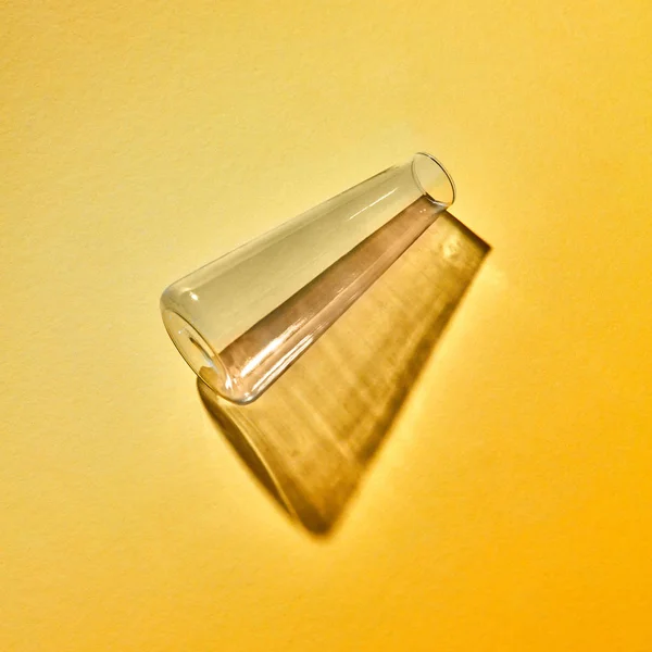 一个玻璃瓶空与反射和阴影位于黄色背景 地方为文本 实验室工具进行实验 实验室理念 — 图库照片