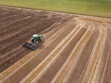 Alandan sonra hasat drone havadan görünümden. Toprak sahada - iş Ekim hazırlığı toprağın hasat sonrası sürme traktör.