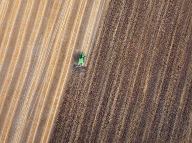 Ekim hazırlığı tarım alanlarının çalışır, bir traktör tarafından toprak tarımı hasadı sonra. Uçan uçak üzerinden hava üstten görünüm