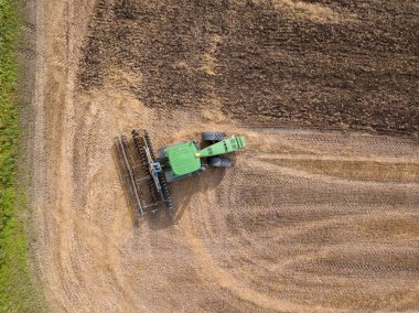 Kuş bakışı görünüme dron hasat sonra alanının üzerinden. Traktör toprak tarım iş için hazırlanıyor bu alanın pulluklar. Üstten görünüm