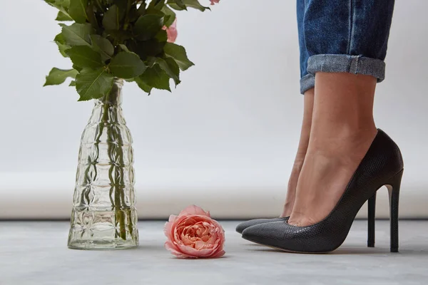 Schöne Frauenbeine Schwarzen Stöckelschuhen Und Jeans Eine Frische Rosa Rose — Stockfoto