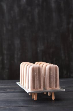 Buz lolly. Siyah ahşap arka plan kopya alanı metin için plastik formda kahve ev yapımı sorbe