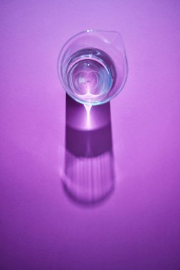 Yumuşak uzun gölgeler ve bardak su ile metin altında yer yüzeyindeki yansımaları. Üstten görünüm