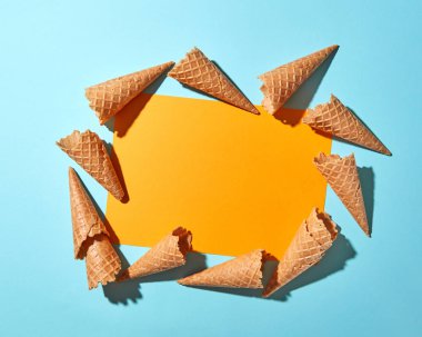 Kopya alanı bir çift ton sarı mavi kağıt zemin üzerine tatlı tatlı waffle külah. Bahar ya da yaz gıda kavramı. Üstten görünüm.