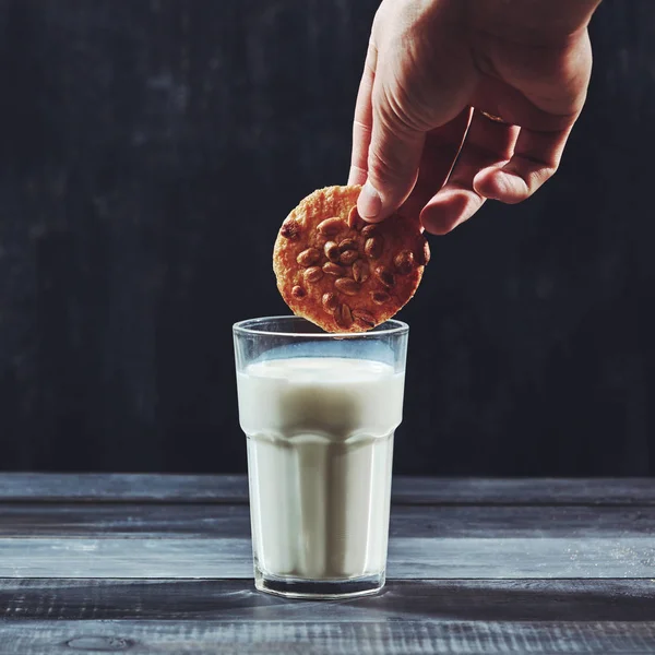 Vrouwelijke Hand Hebt Van Een Pinda Koekje Een Glas Melk — Stockfoto