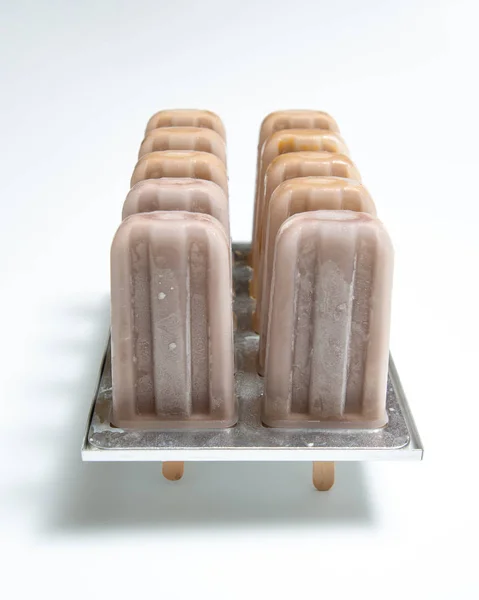 自制有机巧克力冰淇淋棒棒糖在塑料模具与阴影的影子在白色背景与复制空间 — 图库照片